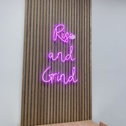 a neon sign that reads rise and grind