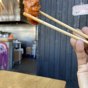 Kuma Ani - a hand holding a pair of chopsticks - Ramen Near Me - Albany, New York Kuma Ani - a hand holding a pair of chopsticks - Ramen Near Me - Albany, New York