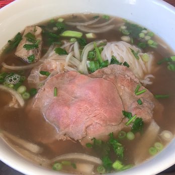 Hanco’s - Beef Pho was not too fatty - A bowl of beef pho featuring slices of beef, rice noodles, chopped green onions, and herbs in a clear broth. - Vietnamese Near Me - Brooklyn, New York
