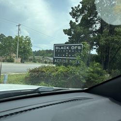 Black Ops Paintball and Airsoft Store - Overgrown weeds around sign.