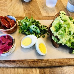 The Bistro - Loaded avocado toast with green onion, oil-salted arugula, pickled red onion, tomatoes and a hard boiled egg on the side. Delicious!