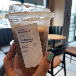 a hand holding a cup of iced coffee a hand holding a cup of iced coffee