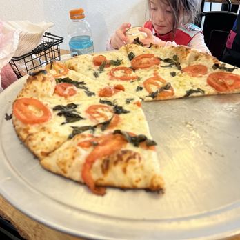 Cove & Craft - a little girl eating a slice of pizza - Pizza Near Me - Dillon, Colorado