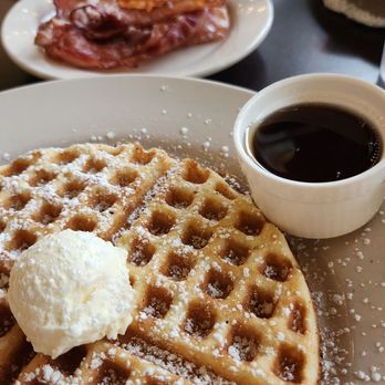 The Leaning Maple - Classic waffle, side of bacon, Strawberry waffle in background. - Coffee & Tea Near Me - Olympia, Washington The Leaning Maple - Classic waffle, side of bacon, Strawberry waffle in background. - Coffee & Tea Near Me - Olympia, Washington