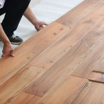 Precise Home Renovations - a man laying laminate on the floor - Flooring Near Me Precise Home Renovations - a man laying laminate on the floor - Flooring Near Me