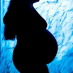 Faded Imagery LLC - Maternity silhouette portrait with blue backlighting, photographed by Faded Imagery LLC.
