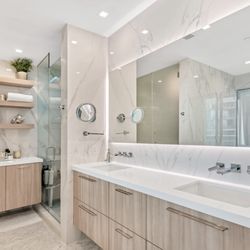 KabCo Kitchens - Modern bathroom design featuring light wood cabinetry, porcelain walls, and integrated lighting for a clean, spa-like look.