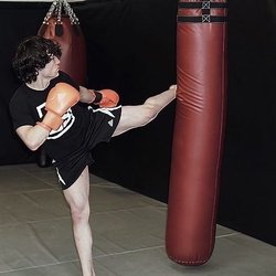 Counterstrike Gym - A student kicking a heavy bag.