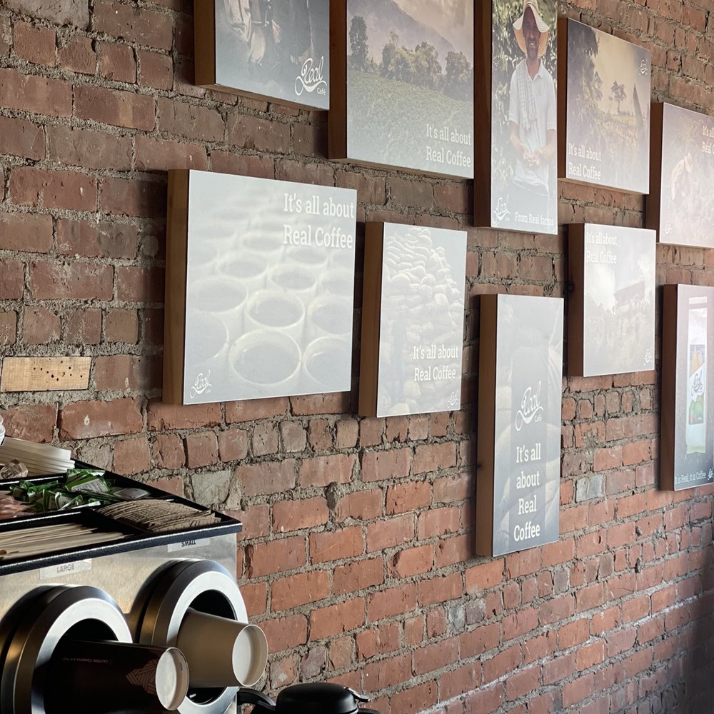 Cafe Real - a brick wall with pictures on it - Coffee Roasteries Near Me - Bristol, Connecticut