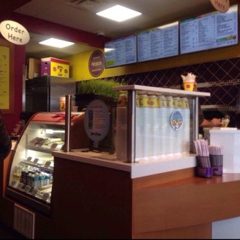 Booster Juice - a man standing in front of a counter - Juice Bars & Smoothies Near Me - Milton, Ontario