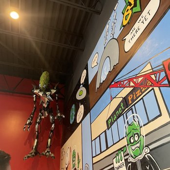 Planet Pizza - a man looking at a mural - Pizza Near Me - Virginia Beach, Virginia