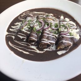Chicken and Gouda cheese enchiladas in a black bean sauce