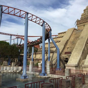 Jaguar! - Riders on the Jaguar in a tight right turn, with the cool Jaguar pyramid in the background. - Amusement Parks Near Me - Buena Park, California