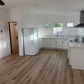 Moore Quality Builders - a kitchen with white cabinets and wood floors - General Contractors Near Me - San Diego, California