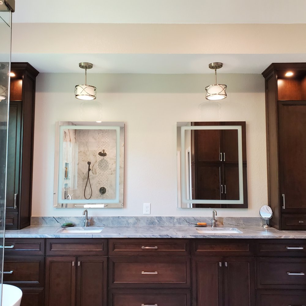 Capital City Tradesmen - a bathroom with dark wood cabinets and a marble countertop - General Contractors Near Me
