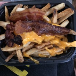 bacon and cheese fries in a black container