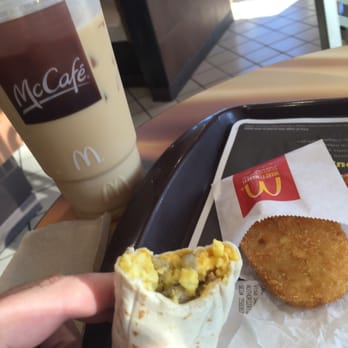 McDonald's - a hand holding a burrito and a cup of coffee - Fast Food Near Me - West Conshohocken, Pennsylvania McDonald's - a hand holding a burrito and a cup of coffee - Fast Food Near Me - West Conshohocken, Pennsylvania