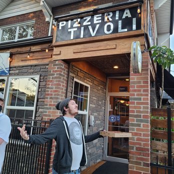 Pizzeria Tivoli - a man standing in front of a restaurant - Pizza Near Me - Saint Louis, Missouri