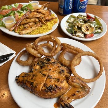 Grillado's - a plate of food with onion rings - Portuguese Near Me - Montreal, Quebec