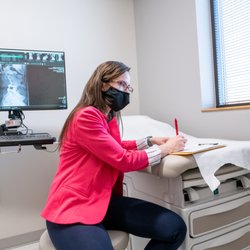Neurosurgery One - Littleton - Dr. Angie Bohnen writing a prescription for a neurosurgery patient.