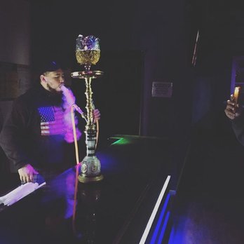 Hydra Lounge - a man smoking a hooket at a bar - Hookah Bars Near Me - Ozone Park, New York