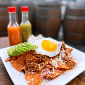 Photo of Lucho's - San Francisco, CA, United States. 1/2 Order Chilaquiles ($8.50) w/ cochinita pibil, Yucatán roasted pork ($3.25), avocado ($3)