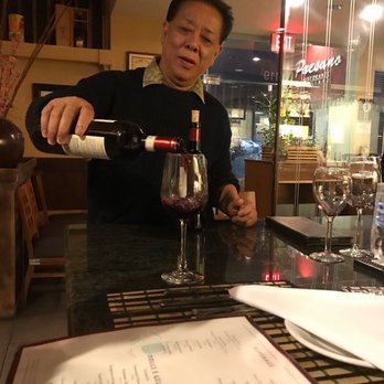 Paesano - Owner is helping my boyfriend find the "buttery" wine he wanted. - Italian Near Me - Aiea, Hawaii