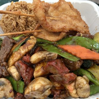 China Taste - Triple delight combo - A takeout container holds fried chicken pieces, seasoned rice, and a mix of stir-fried vegetables including mushrooms, carrots, broccoli, and snap peas, all served with a savory sauce. - Chinese Near Me - Windham, Maine