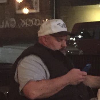 ampm - a man sitting at a table looking at his cell phone - Convenience Stores Near Me - Merced, California