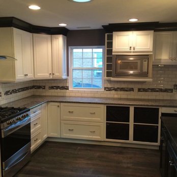Berkley Construction - a kitchen with white cabinets and black appliances - General Contractors Near Me Berkley Construction - a kitchen with white cabinets and black appliances - General Contractors Near Me