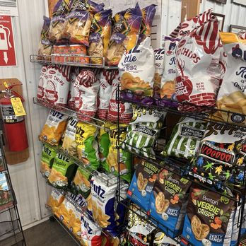 Country Market - Display of snack bags such as potato chips and veggie crisps on metal shelves in a grocery store aisle. - Meat Shops Near Me - Springfield, Illinois