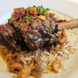 Lamb Shank: braised lamb shank au jus topped w/ nuts and served w/ rice.