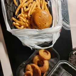 The Draft Sports Bar & Grill - Bushwacker burger, fries, and onion rings in take out boxes
