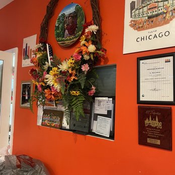El Tezcal Mexican Restaurant - an orange wall with a wreath of flowers - Mexican Near Me - Chicago, Illinois