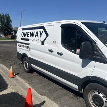 Oneway Locksmith - A white locksmith service van with the business name 'Oneway Locksmith' is parked on a street, with orange traffic cones placed nearby. - Keys & Locksmiths Near Me