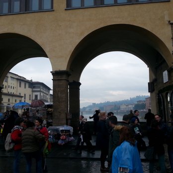 Ponte Vecchio - Halfway across the bridge is an open area where vendors show their wares and tourist take photos. - Local Flavor Near Me - Florence, FI Ponte Vecchio - Halfway across the bridge is an open area where vendors show their wares and tourist take photos. - Local Flavor Near Me - Florence, FI