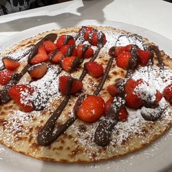 Pancake with powdered sugar, strawberries, and Nutella.