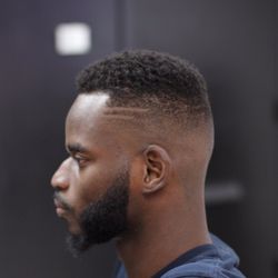 Xclusiv Barber Lounge - Curled top with skin fade, custom design, sharp lines with beard.