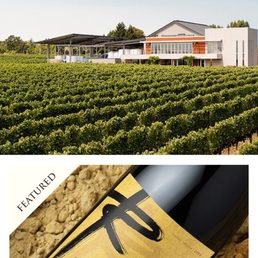 a bottle of wine in front of a vineyard
