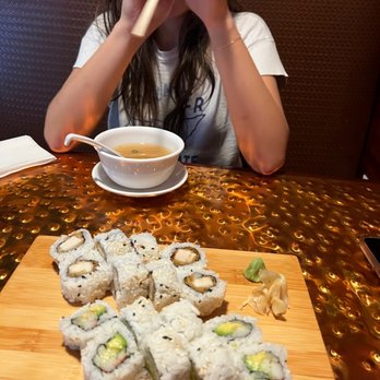 Ocean Blue Sushi - a woman eating sushi with chopsticks - Sushi Bars Near Me - Clearwater, Florida