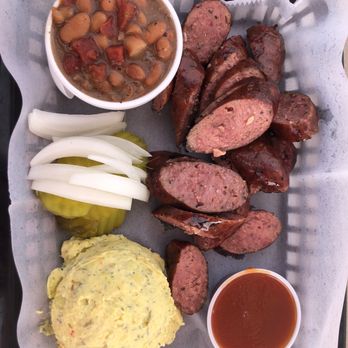 Que Zeen Barbecue Cuisine - Sausage plate with a side of brisket beans, a side of dilled potato salad, fresh onions, and dill pickles - Barbeque Near Me - Ingram, Texas Que Zeen Barbecue Cuisine - Sausage plate with a side of brisket beans, a side of dilled potato salad, fresh onions, and dill pickles - Barbeque Near Me - Ingram, Texas