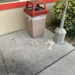 Look at the grease on the sidewalk. Trash all around Look at the grease on the sidewalk. Trash all around