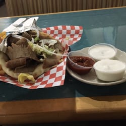 Traditional gyro with sides of cucumber and hot sauce served with fries.