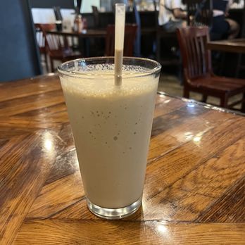 Drip Cafe - a glass of milkshake on a wooden table - Coffee & Tea Near Me - Hockessin, Delaware