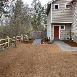 a gravel driveway with a wooden fence