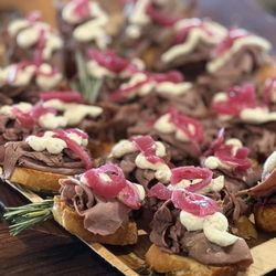 Cafe 191 - Catering crostini topped with sliced with beef, horseradish sauce and pickled onions