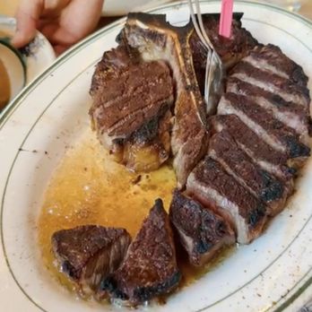 Peter Luger - Steak for two on a sizzling hot plate. The server serves to you and tells you that you can further sear the steak on the side of the plate - Steakhouses Near Me - Brooklyn, New York