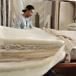 Nicks Got Your Back - Miguel showing off the inside of a raw organic mattress prior to being upholstered.