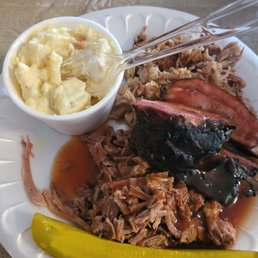 ows a plate of pulled pork, macaroni and cheese and a pickle ows a plate of pulled pork, macaroni and cheese and a pickle