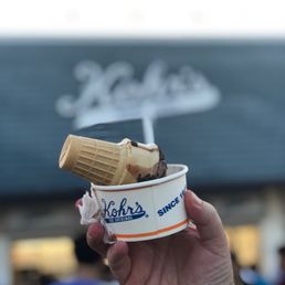 a hand holding a cup of ice cream a hand holding a cup of ice cream